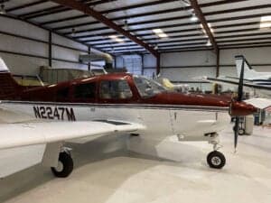 Close-up of N2247M's nose and propeller in a hangar setting.