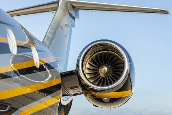 A close-up of the jet engine on the N1Y Embraer Legacy 500, showing the turbine blades and black and yellow paint.