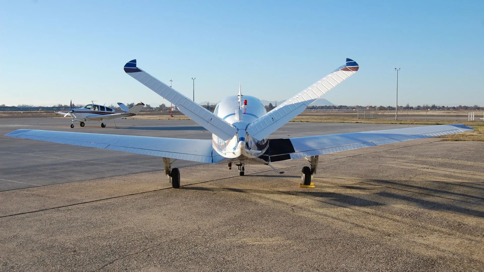 Rear view of the aircraft on the tarmac, showing the tail and wings.