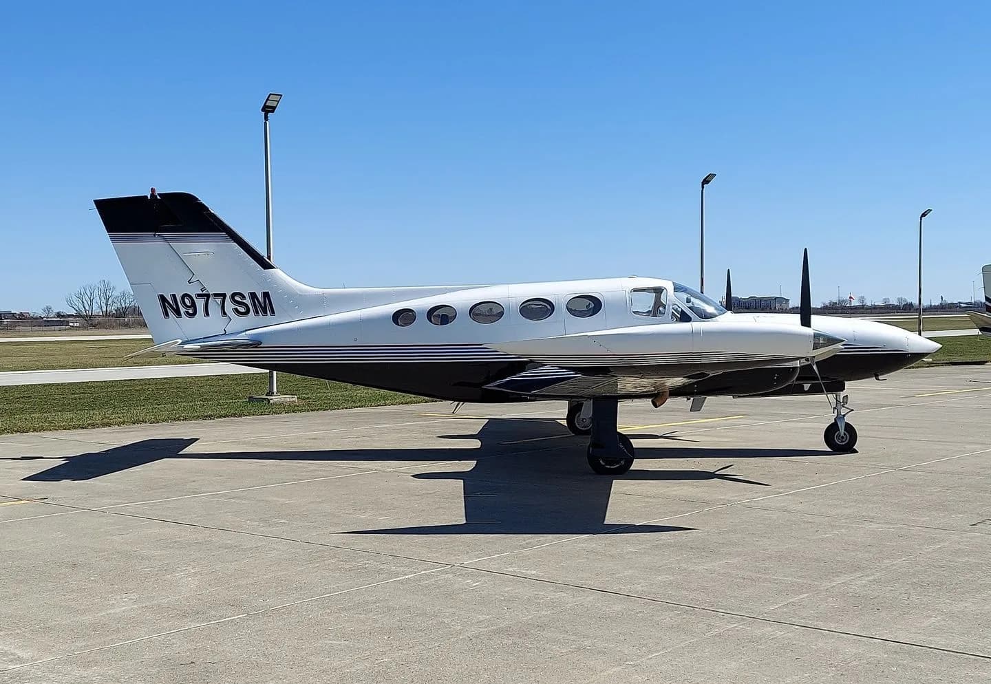 Side profile of a Cessna 414 aircraft with registration N977SM on the ground.