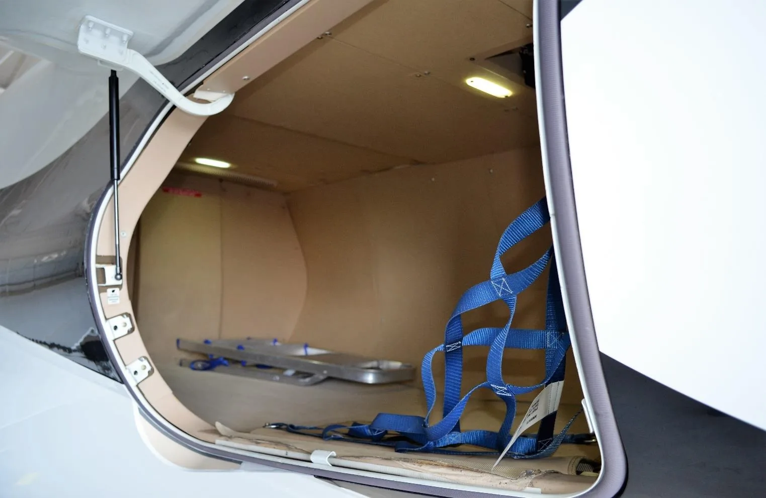 The Phenom 300E features a baggage compartment with a net and ladder.