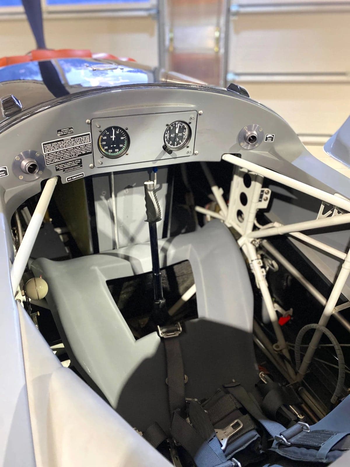 Rear view of a red and white Extra EA-300LX with the canopy open.