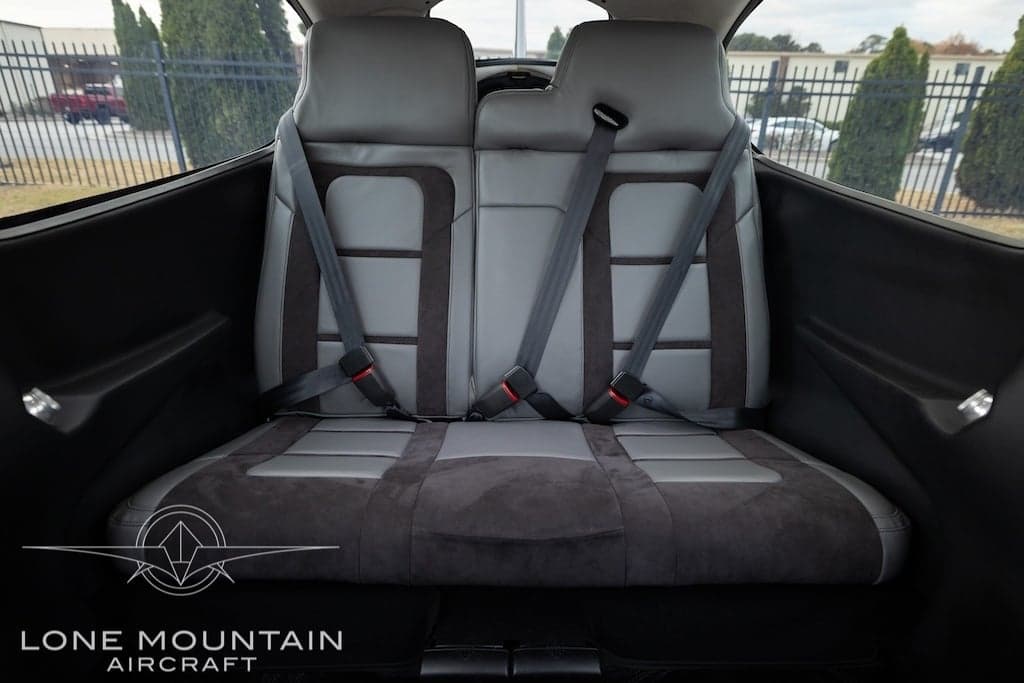 The rear seats of a Cirrus SR22T aircraft are upholstered in gray leather with black accents.