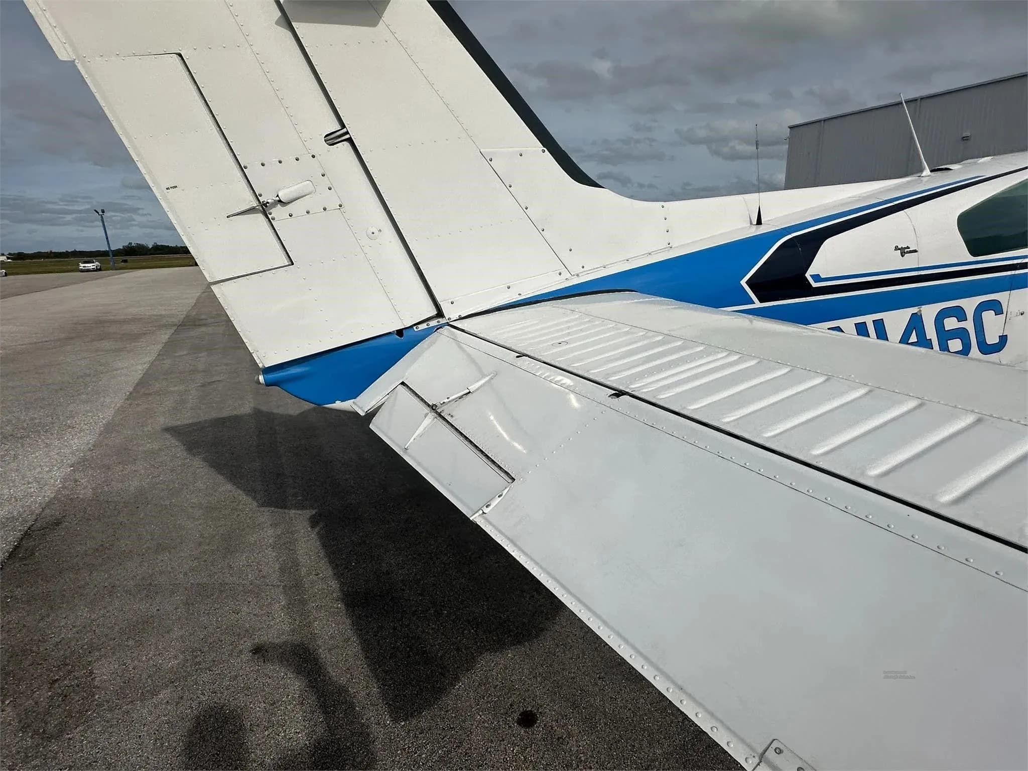 A close-up view of the right wing and tail of the white and blue aircraft N146C.
