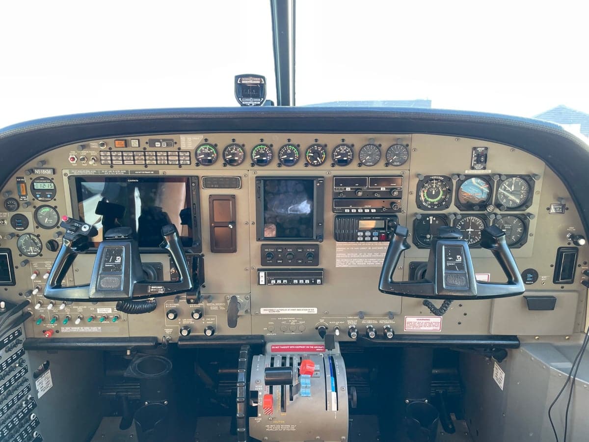 The cockpit of a Cessna Caravan, showing the instrument panel with analog gauges and modern digital displays.