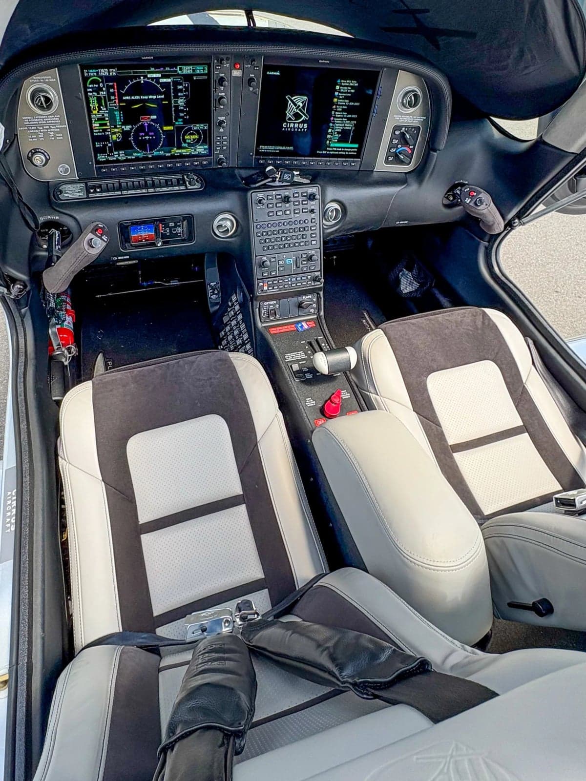 View of the Cirrus SR22T cockpit with modern avionics and gray seats.