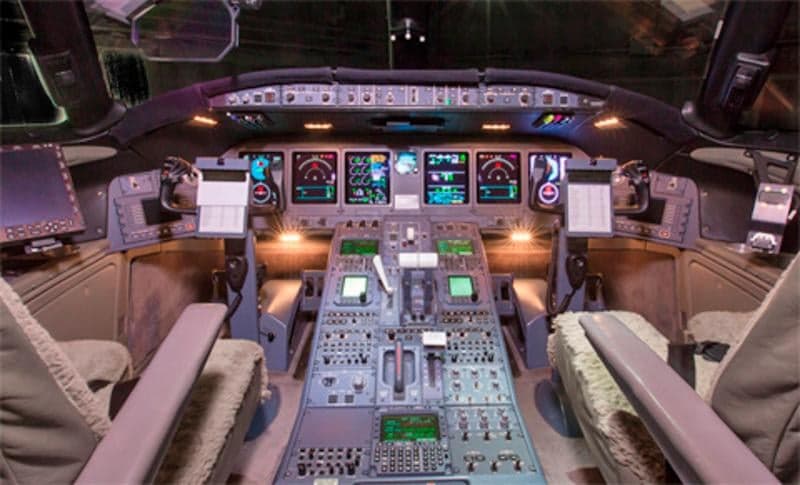 The cockpit of a private jet with multiple displays and controls.