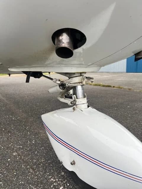 Close-up of the landing gear and exhaust of the C-FZCE Cessna aircraft.