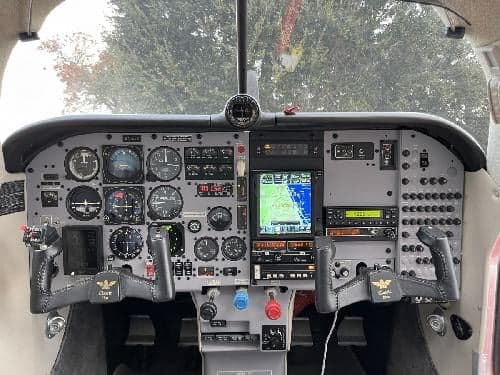 The cockpit features a gray instrument panel with various gauges and controls.