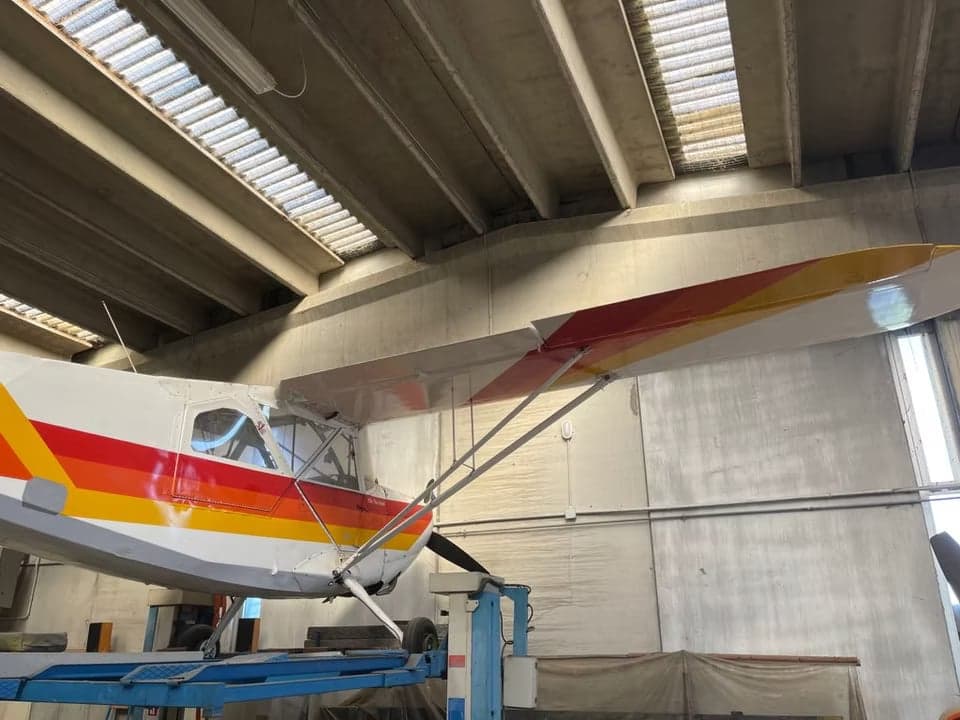 I-AEGS aircraft tail section in a hangar.