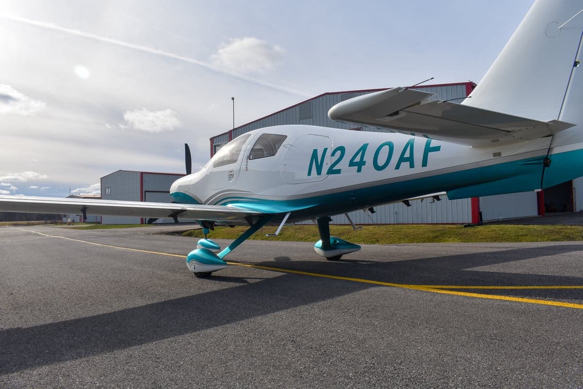 Columbia 400 aircraft with open doors on the ground.
