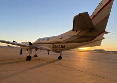 A Metro aircraft with tail number N5441M parked on the tarmac at sunset.