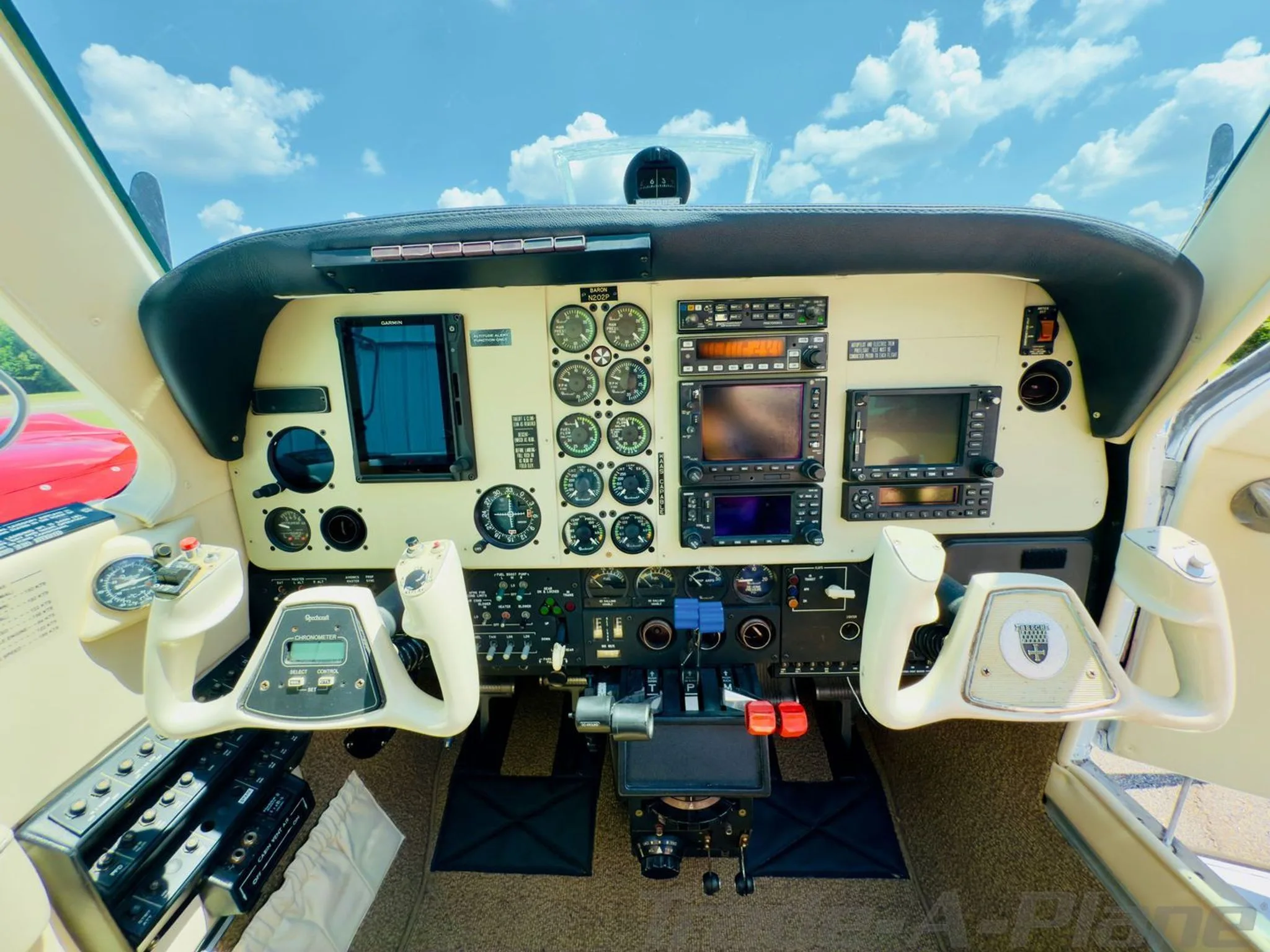 Detailed view of the cockpit instrument panel with multiple gauges, screens, and control yokes.