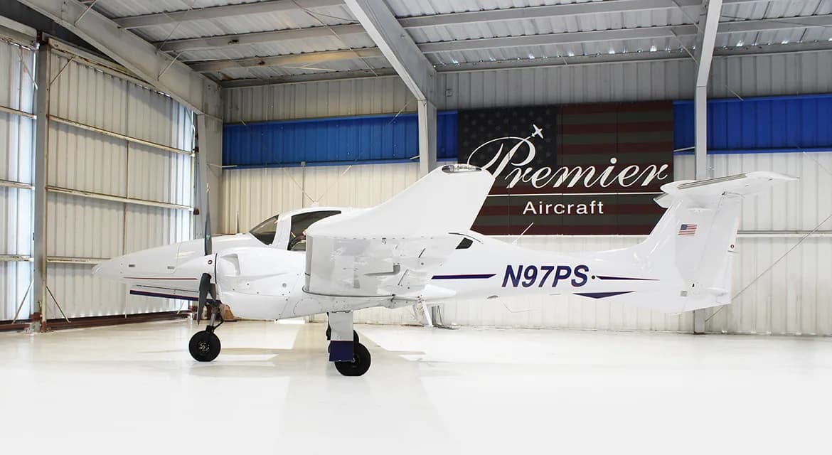 Side view of a Diamond DA62 aircraft with registration N97PS in a hangar.