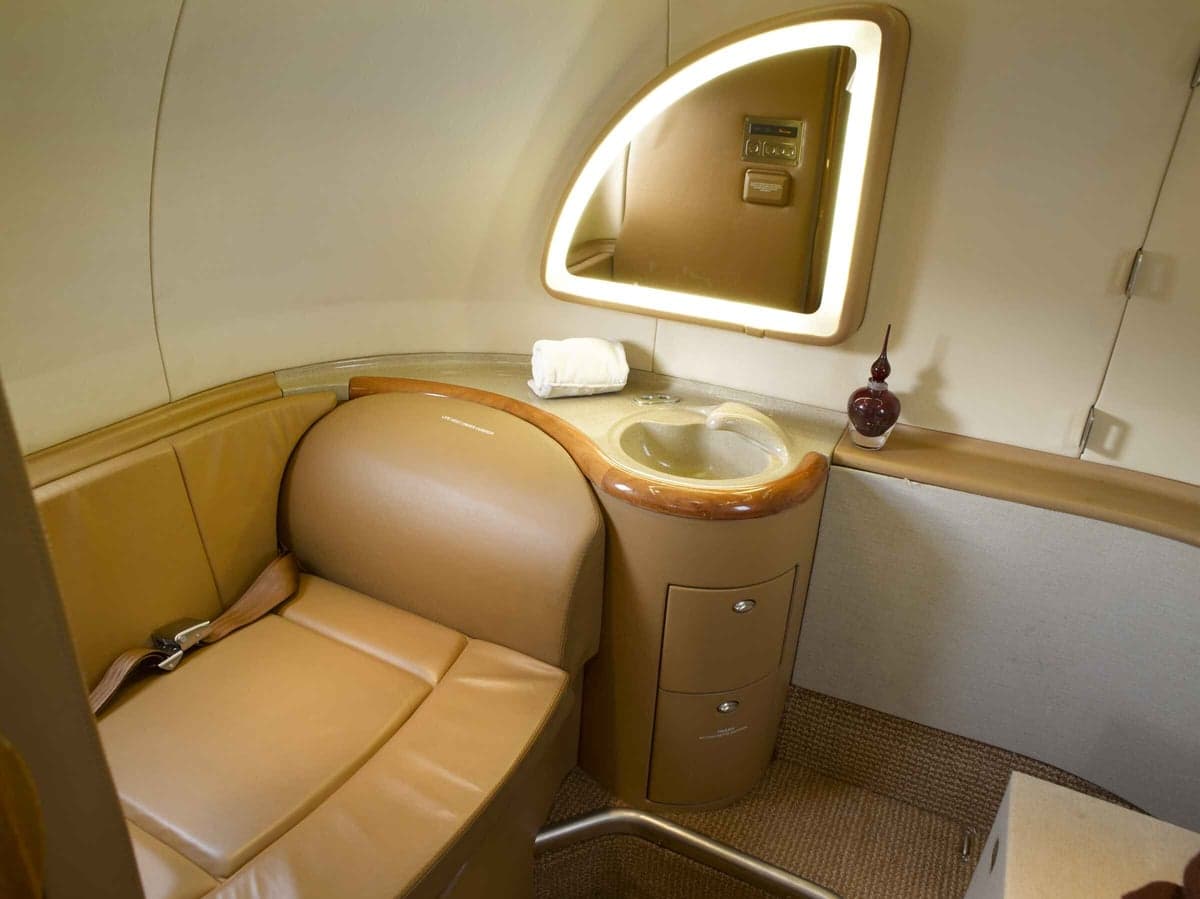 Interior view of the aircraft lavatory with a sink and mirror.