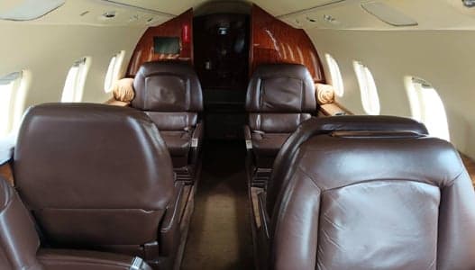 The interior of the Learjet aircraft features leather seats and wood trim.