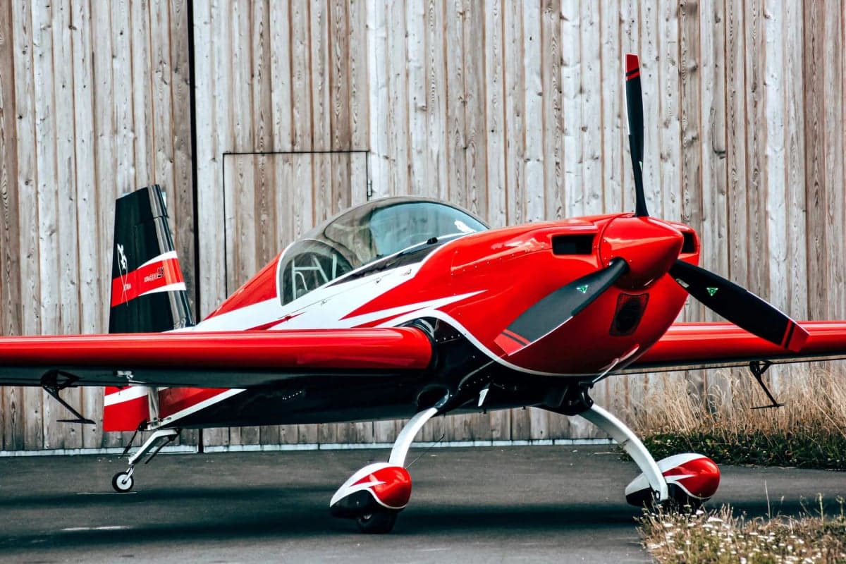 Rear view of a red and white Extra EA-300LX on the tarmac.