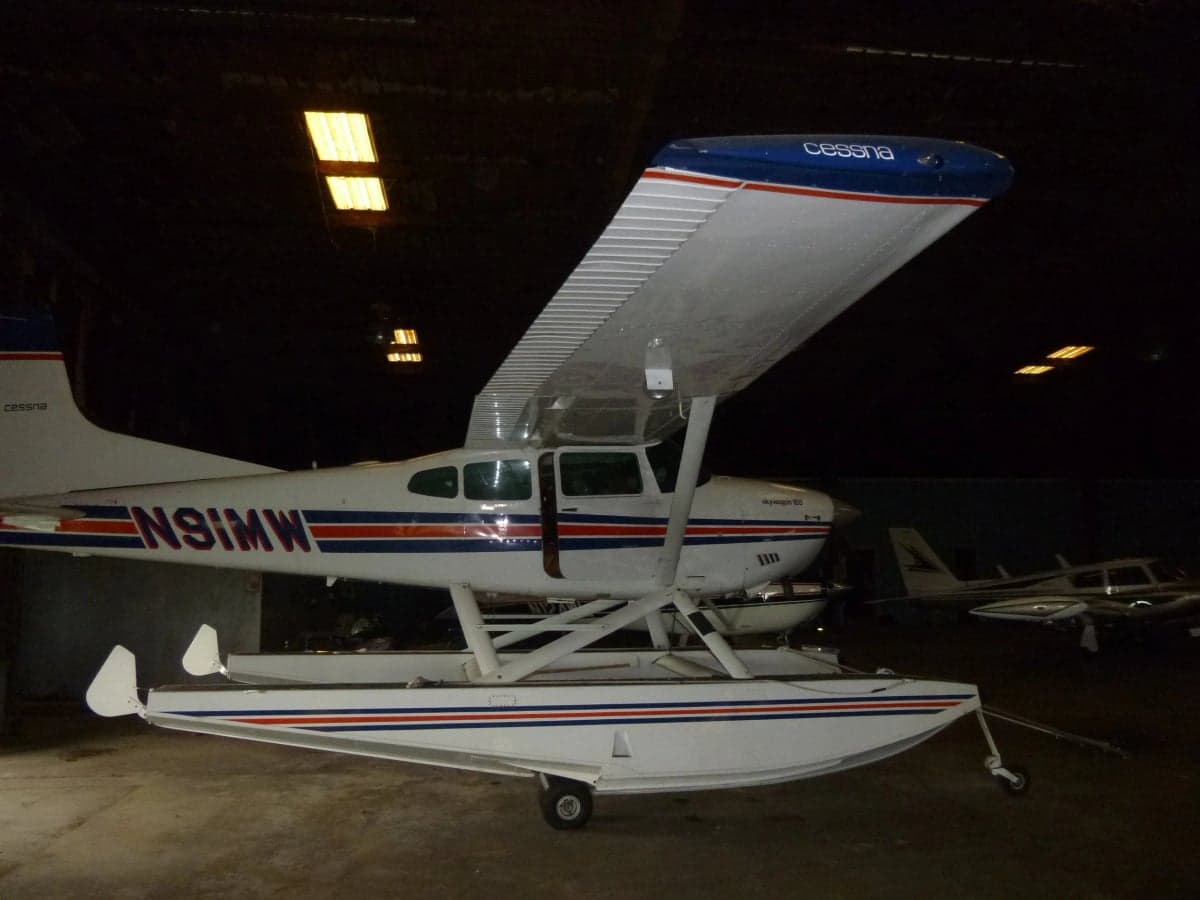 Cessna Skywagon 185 floatplane with registration N91MW in a hangar.