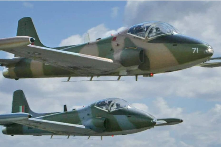 Two SIAI-Marchetti S.211 jets in flight with camouflage paint scheme.