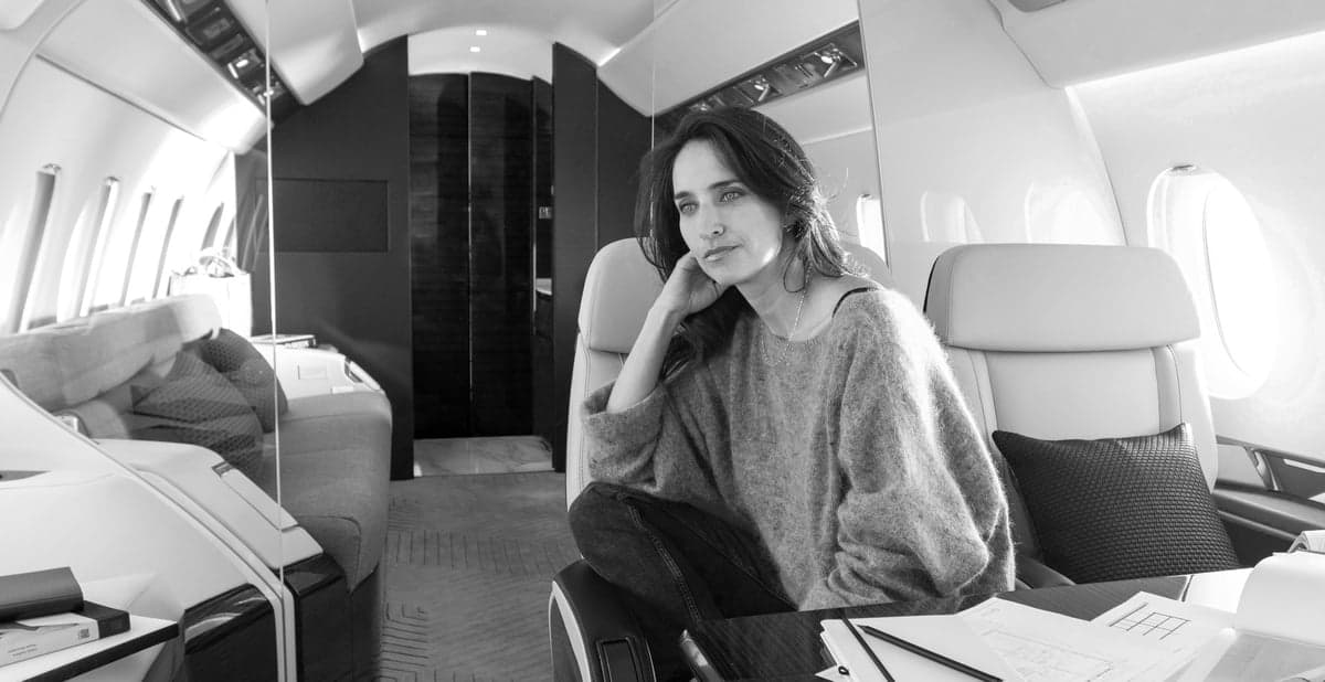 Black and white photo of a woman sitting in the aircraft cabin.