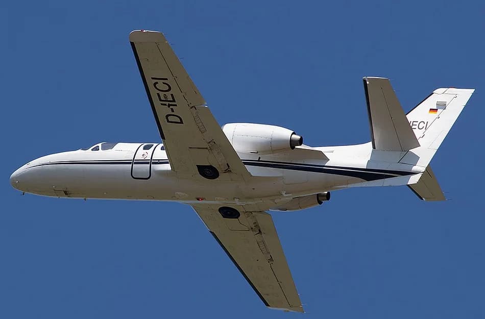 A Cessna Citation Mustang aircraft, registration D-IECI, in flight against a clear blue sky.
