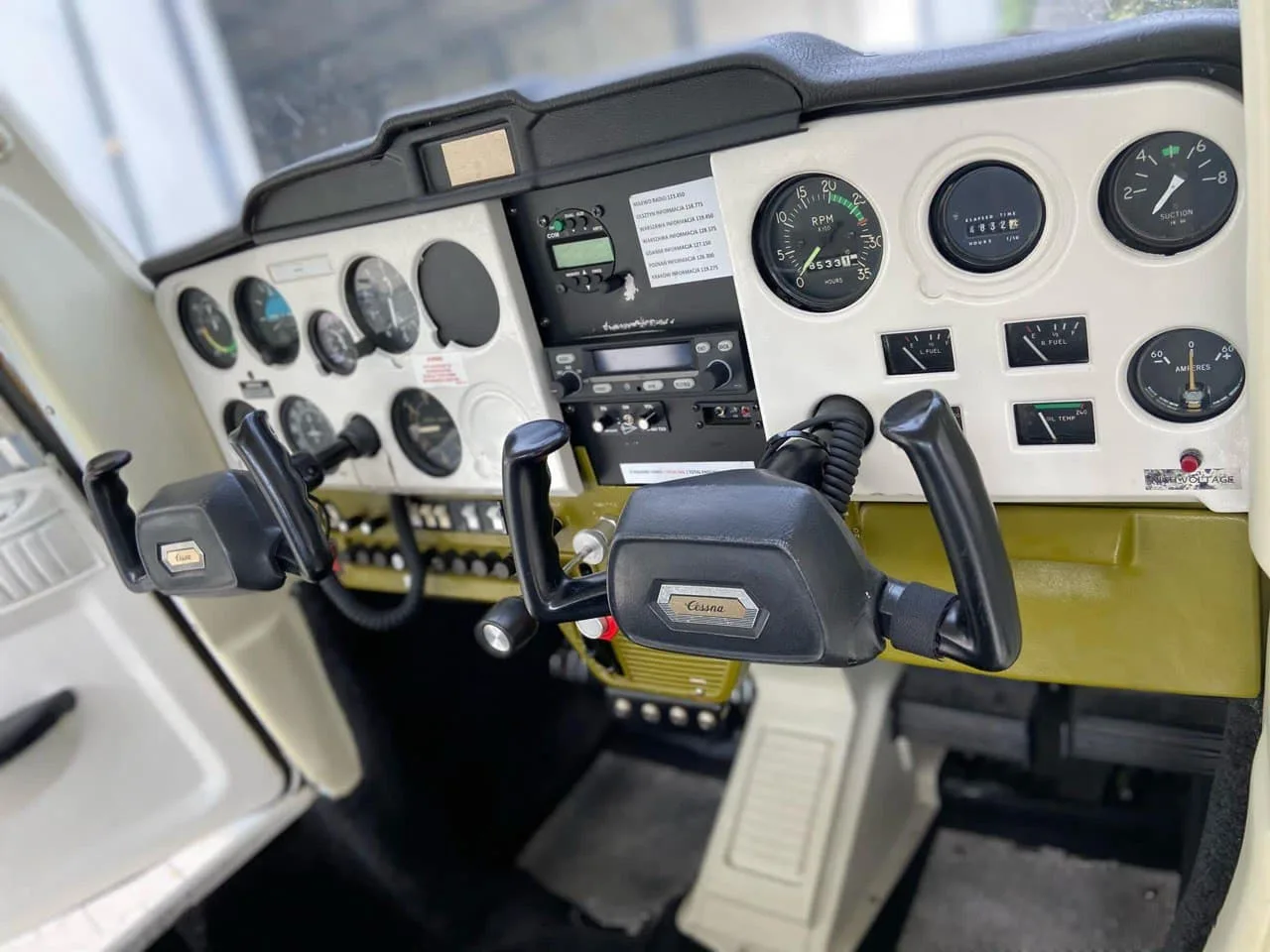 View of the Cessna 150 cockpit instrument panel and yokes.