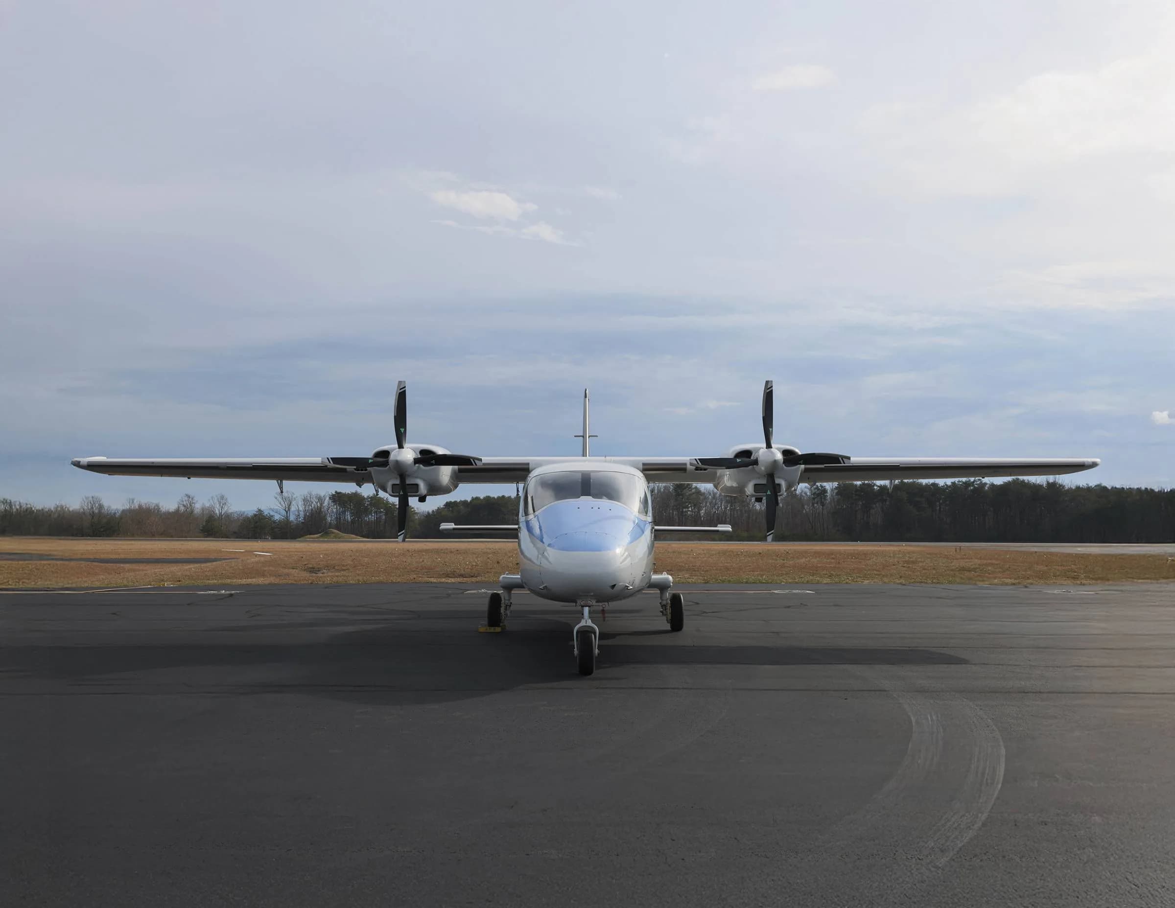 Front view of a white and blue aircraft on the tarmac.