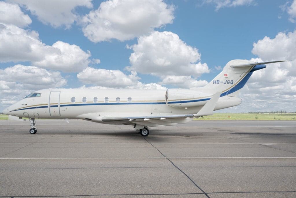 Side view of a Bombardier Challenger 350 aircraft with registration HB-JGQ on the tarmac.