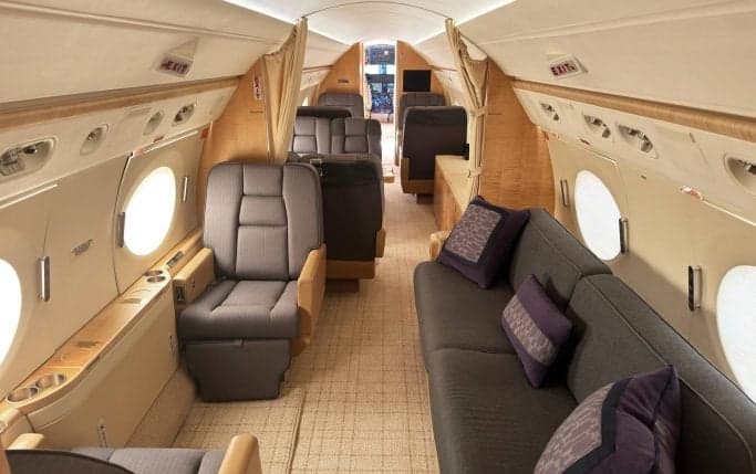Cabin interior with a table, sofa, and seats.