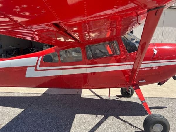 Close-up view of the red and white Cessna Skywagon 180's side and landing gear.