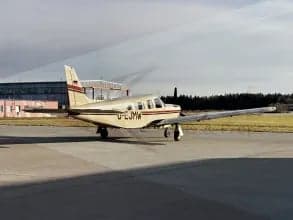 A Piper PA-28-181 Archer II, registration D-EJMW, parked on the tarmac.