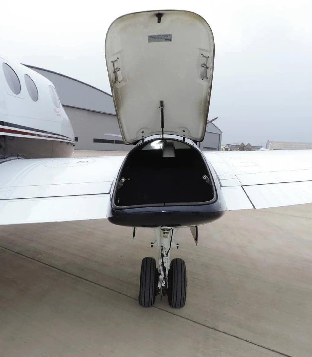 Nose baggage compartment open on a King Air aircraft.