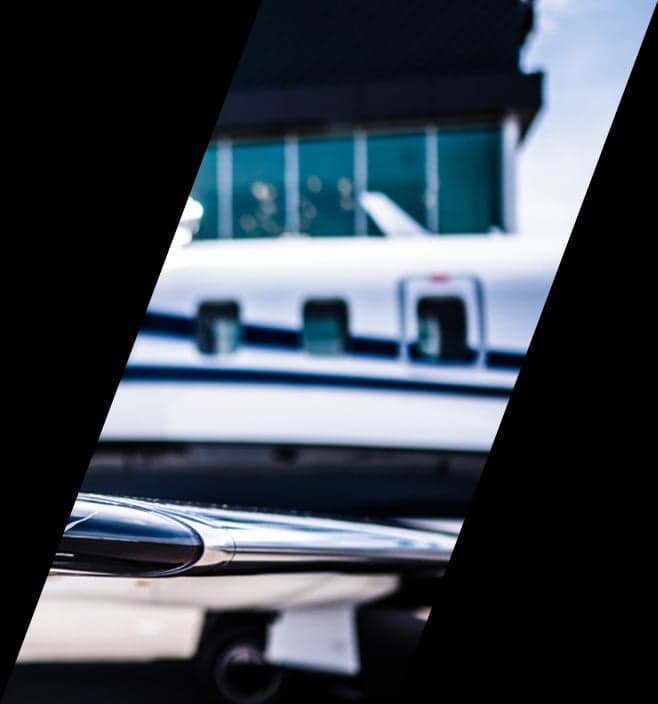 Side view of the fuselage and wing of a white jet with multiple windows.
