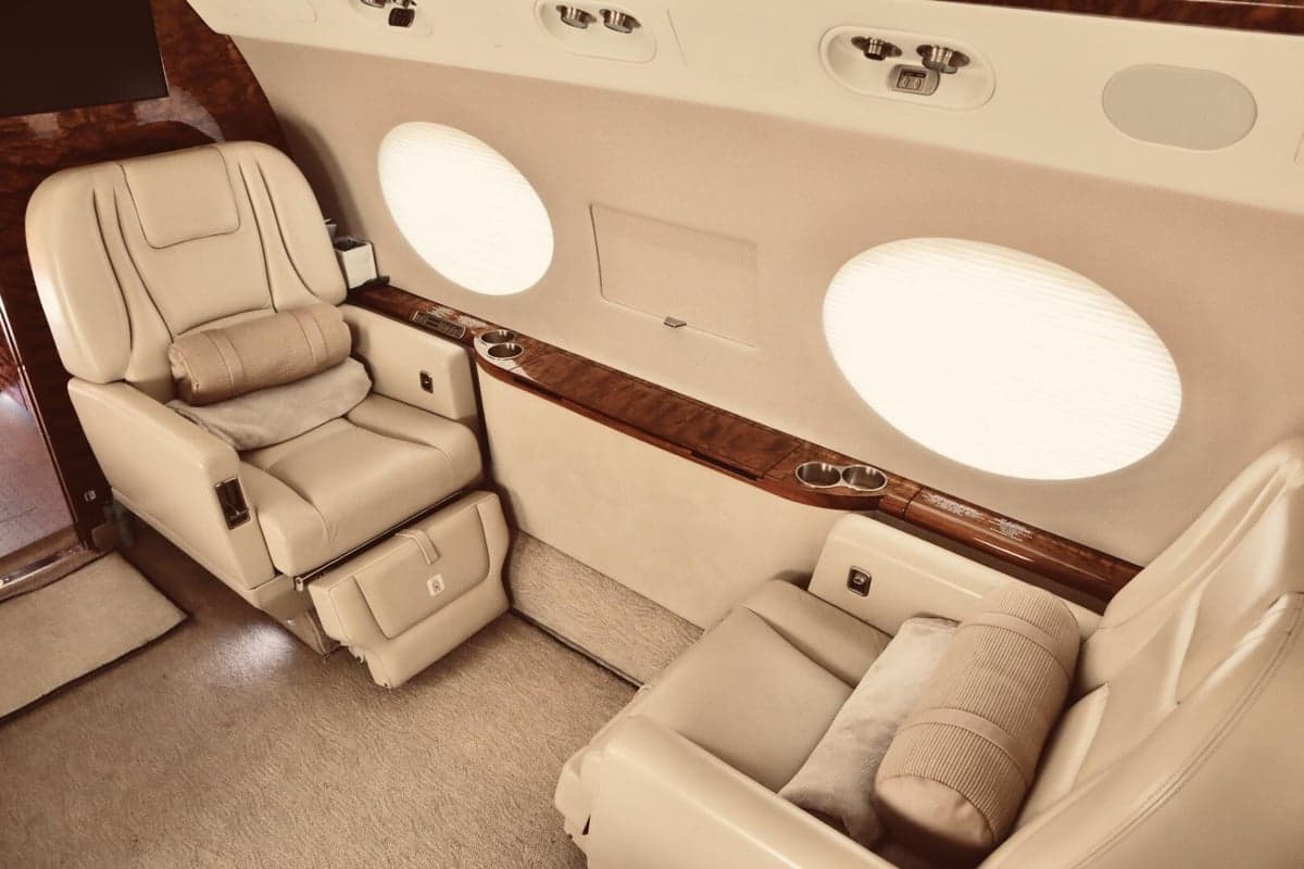 The aircraft's interior features leather seats and wood accents.