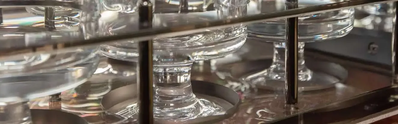 A close-up view of clear glass stemware neatly stored in a rack within the aircraft's galley or bar area.