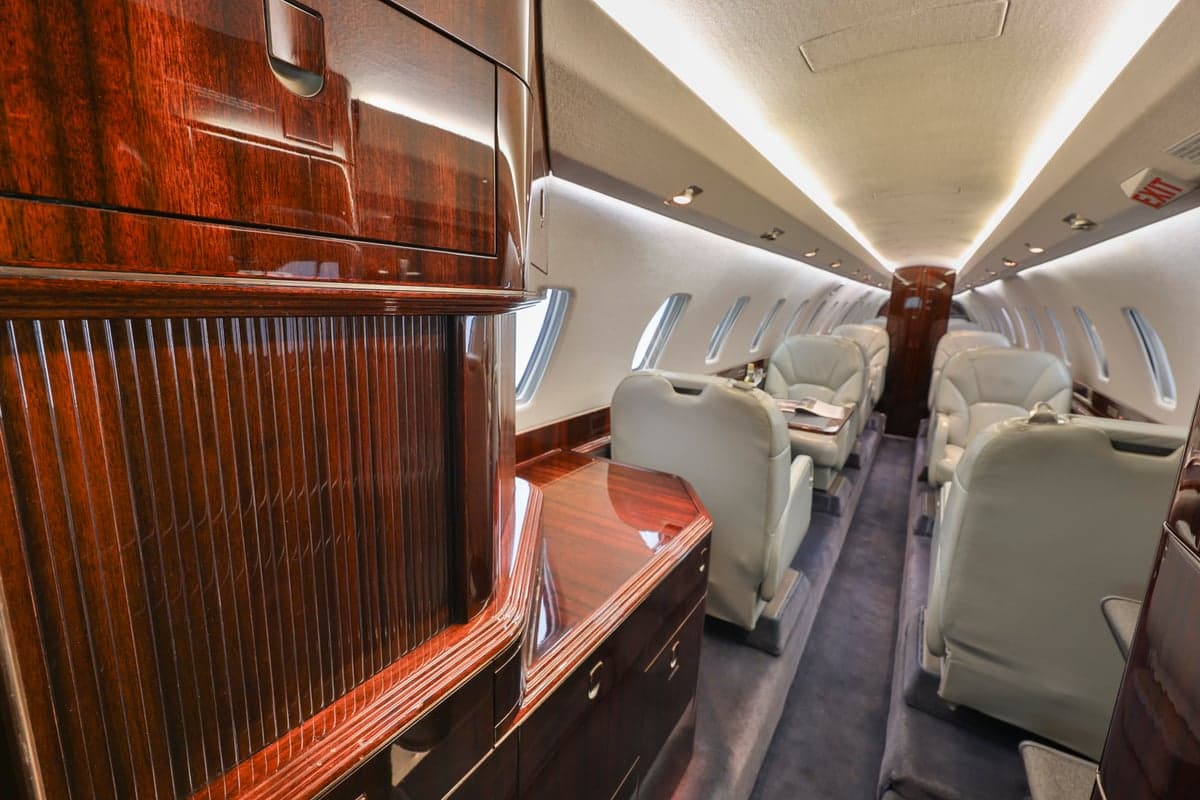 The interior of a Citation CJ3 aircraft, showing the cabin seats and wood trim.