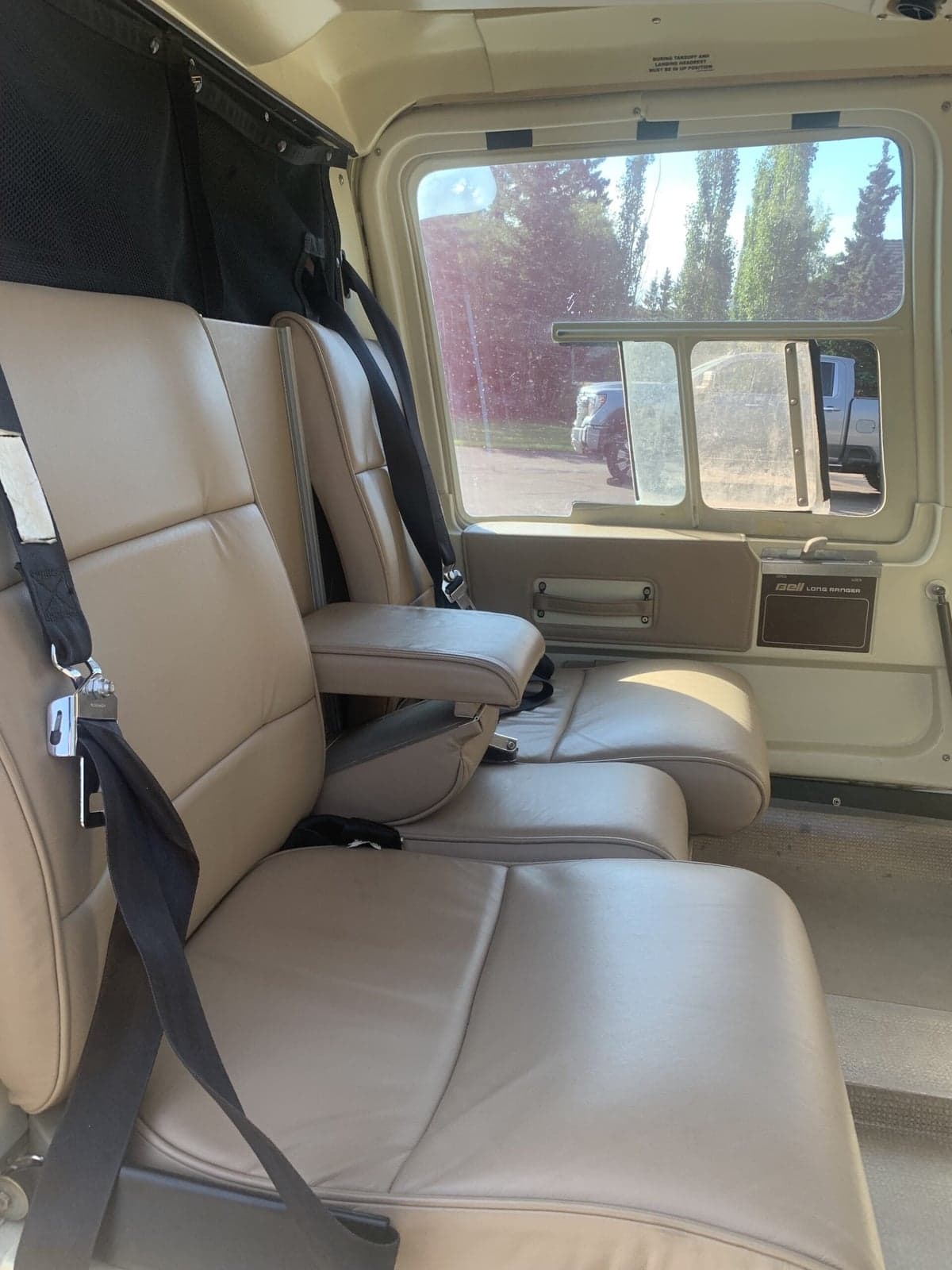Close-up of the Bell 407 helicopter cabin seats with seatbelts.