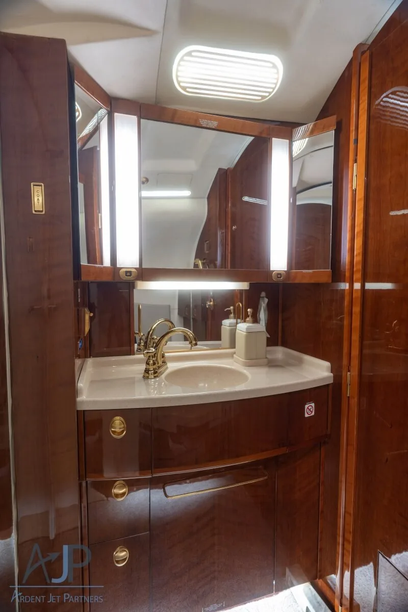 Interior view of the aircraft cabin with leather seats and wood accents.