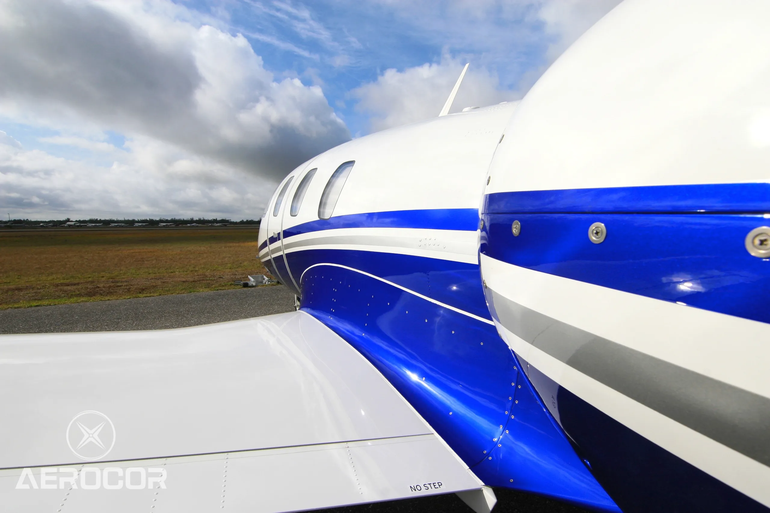 Close-up of the white and blue fuselage and wing of the Eclipse 500 jet, showing the registration N561MJ.