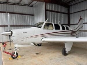 A Beechcraft Bonanza N13RK is parked inside a hangar.