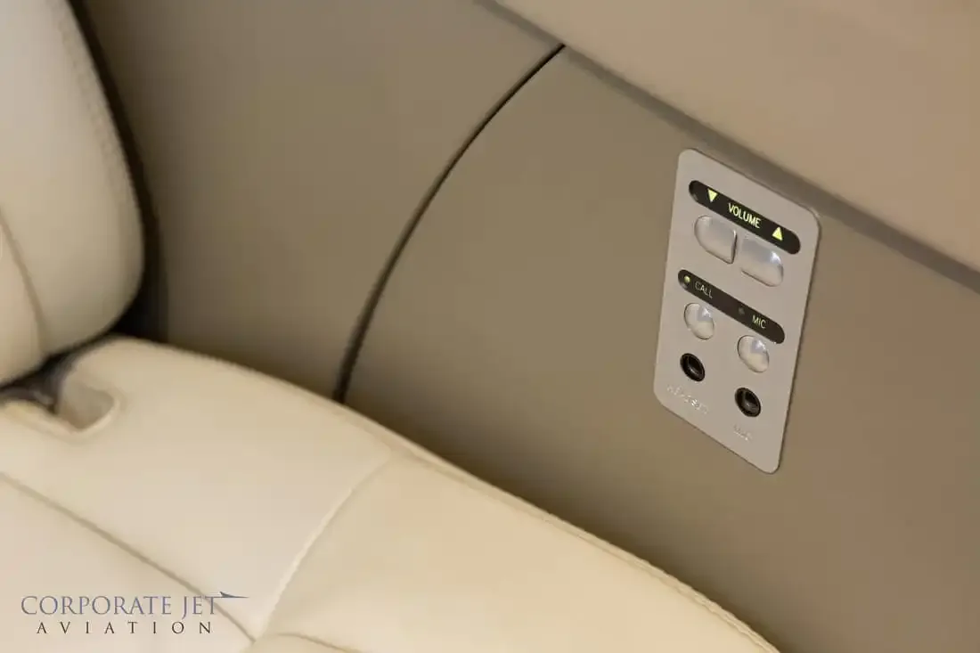 A close-up of a passenger control panel for volume and call functions in the aircraft cabin.