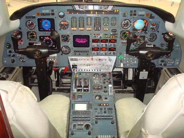 The cockpit of an aircraft with a full instrument panel.