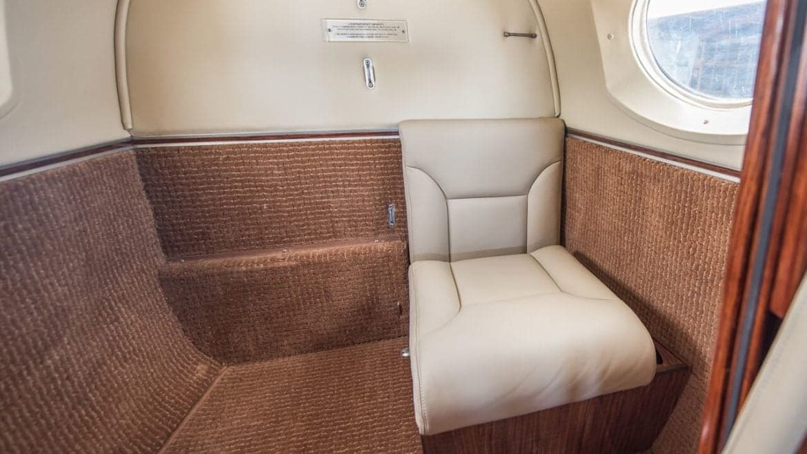Aircraft interior with a single leather seat.