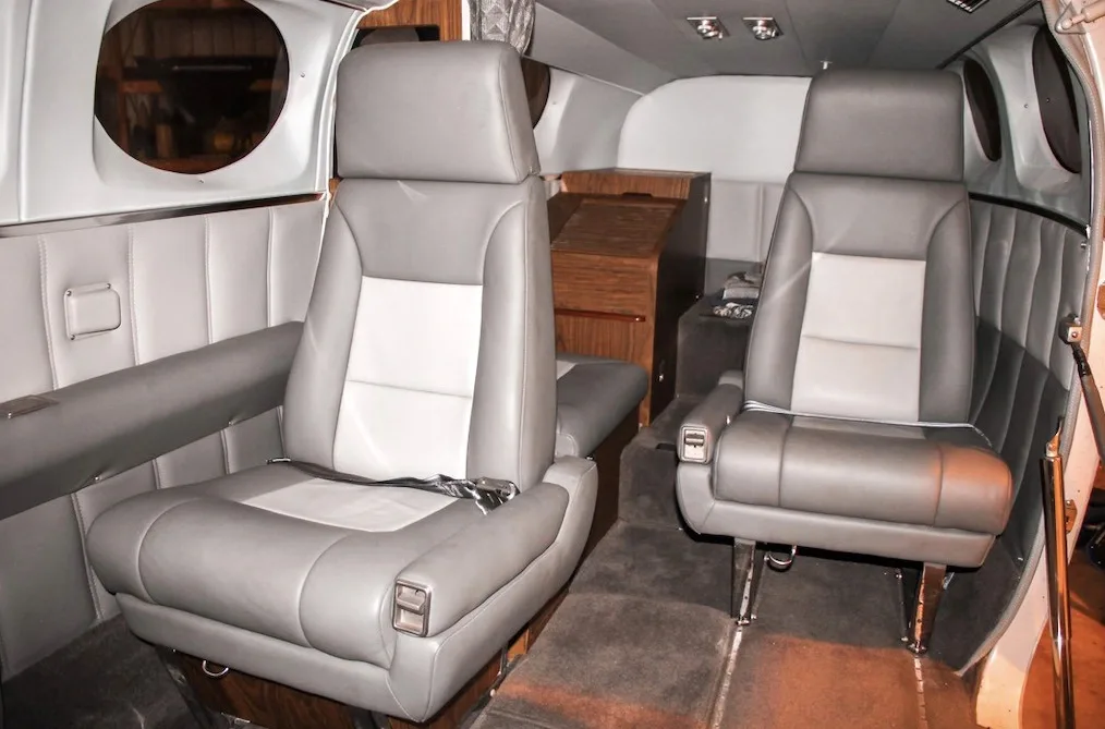 A different angle of the aircraft's cabin interior showing gray and white leather seats.