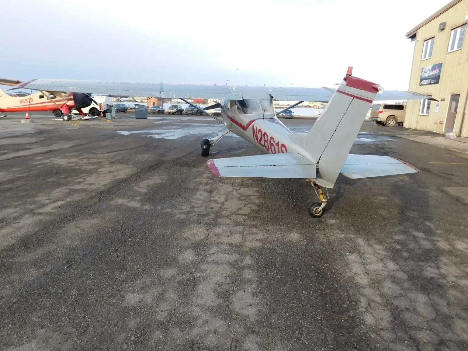 A silver and red single-engine propeller aircraft (N2861S) parked on a tarmac, viewed from the rear-right.