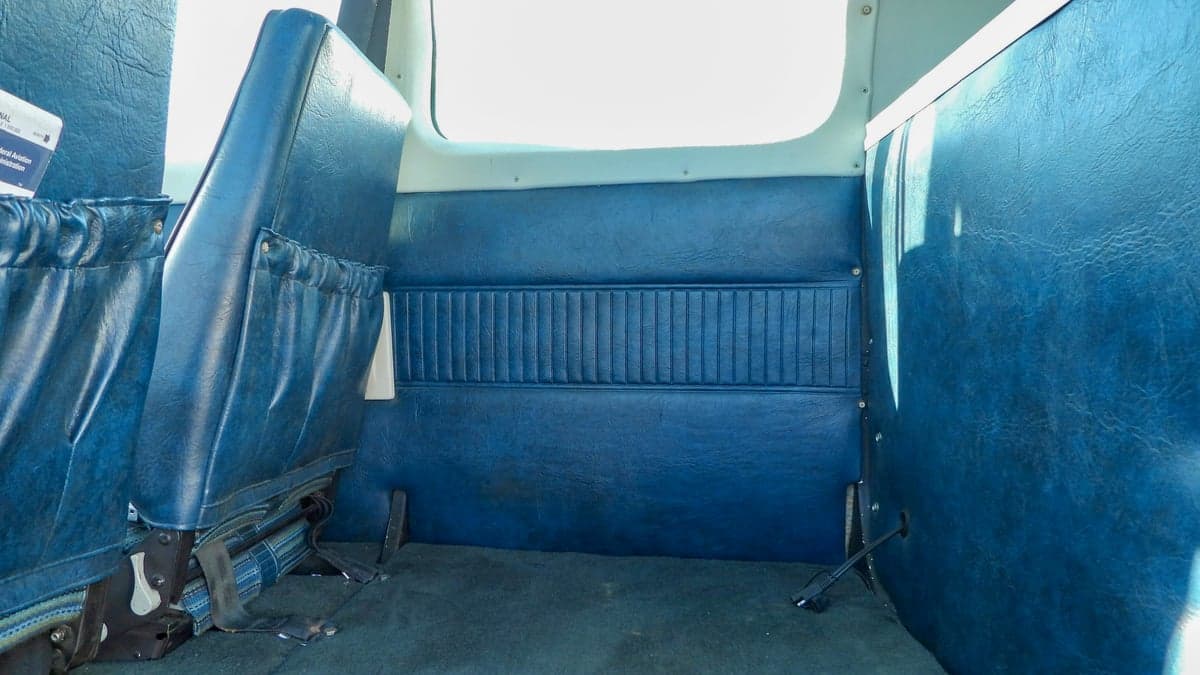 View of the rear blue vinyl interior of the aircraft cabin.