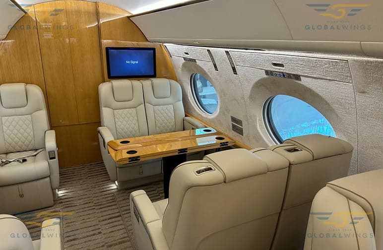 The interior of the aircraft features leather seats and wood trim.