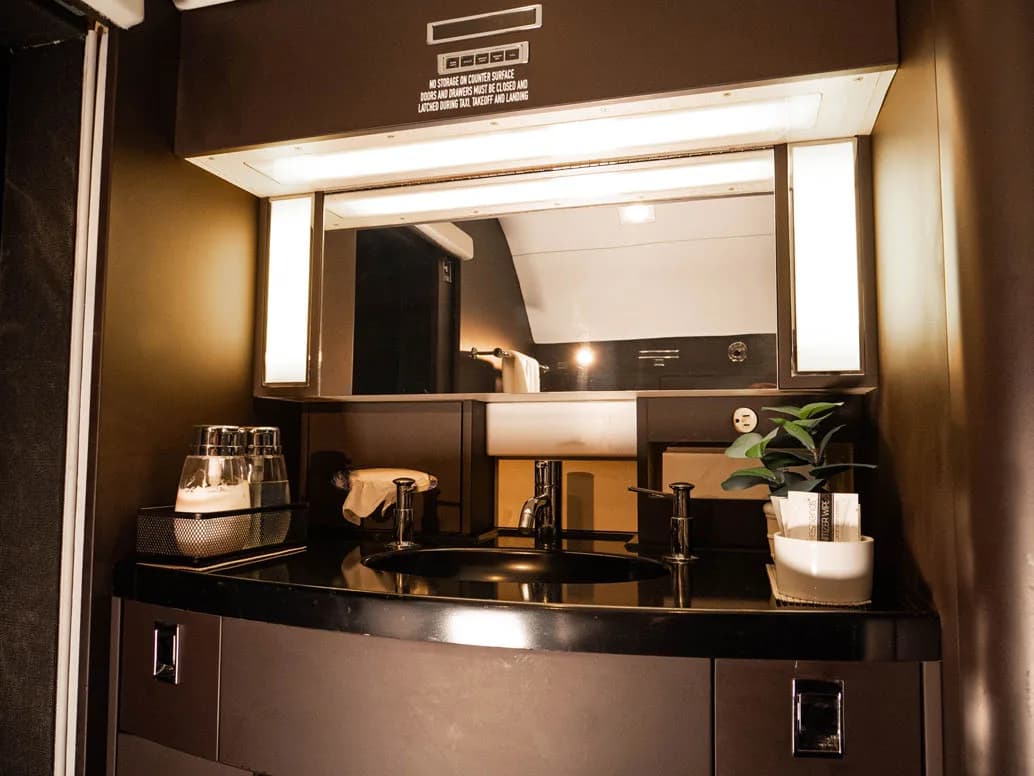 View of the aircraft lavatory with a sink and mirror.