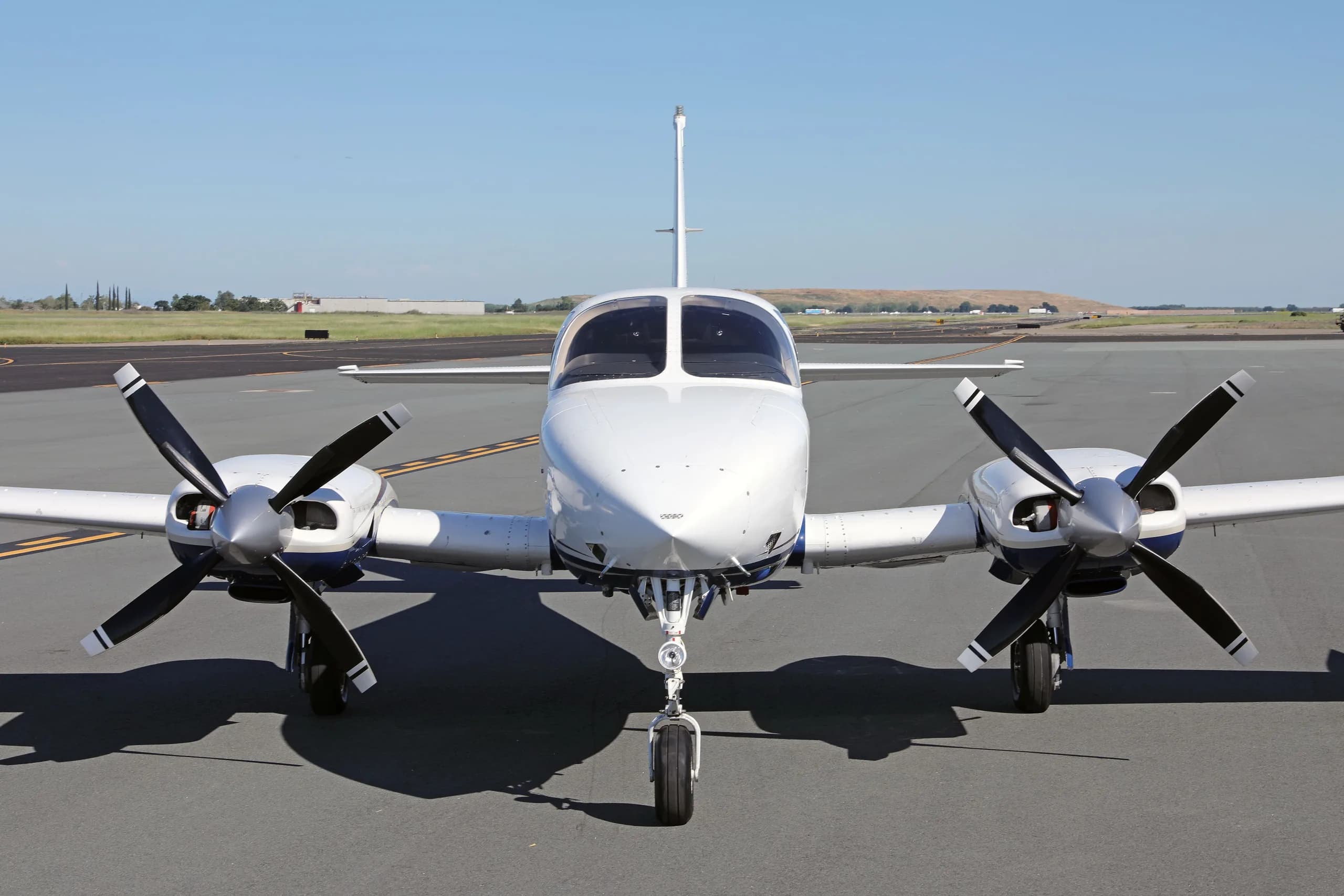 A head-on view of a white and blue Cessna 340 twin-engine aircraft with registration N340U on an airfield.