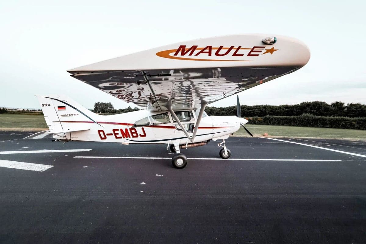 Side view of the D-EMBJ Maule STOL aircraft on the tarmac, showing the wing and registration.